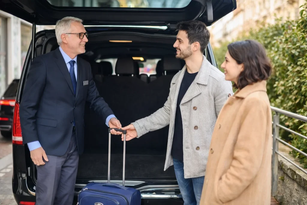 Executive travelers with luggage meeting a chauffeur
