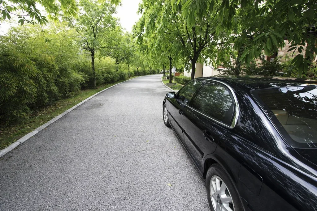 Black sedan pulling into a calm side-street pickup point in Everett