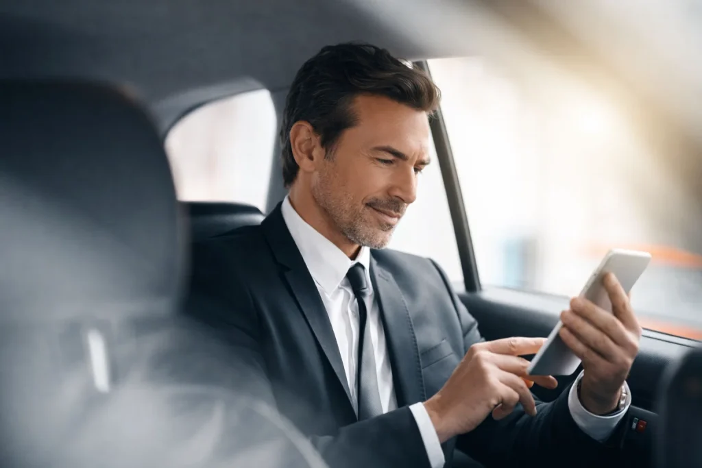 Executive passenger in back seat reviewing a multi-stop schedule
