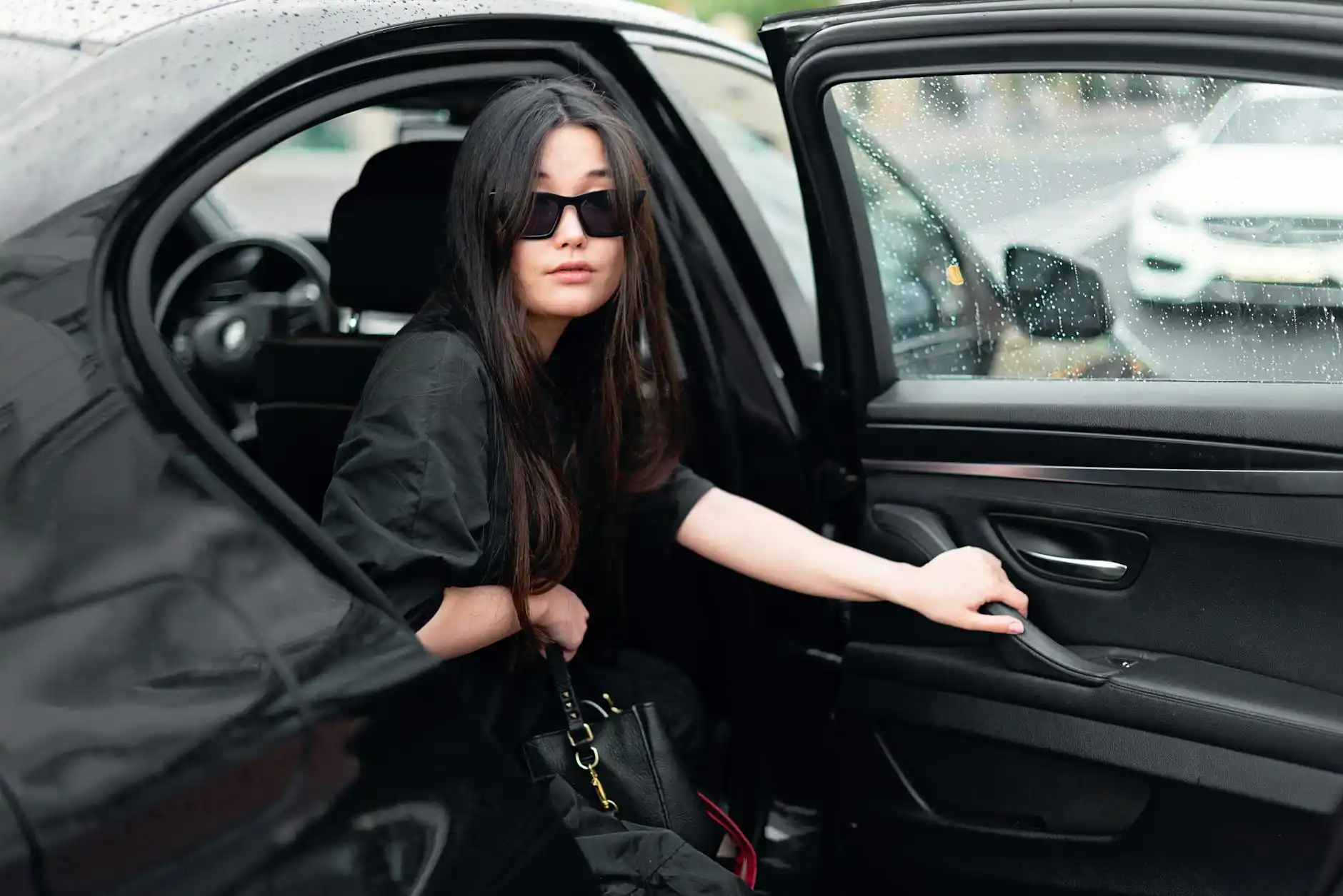 black luxury executive sedan arriving at a glass office tower in downtown Bellevue at sunrise, professionally dressed business traveler stepping out with leather briefcase, clea...