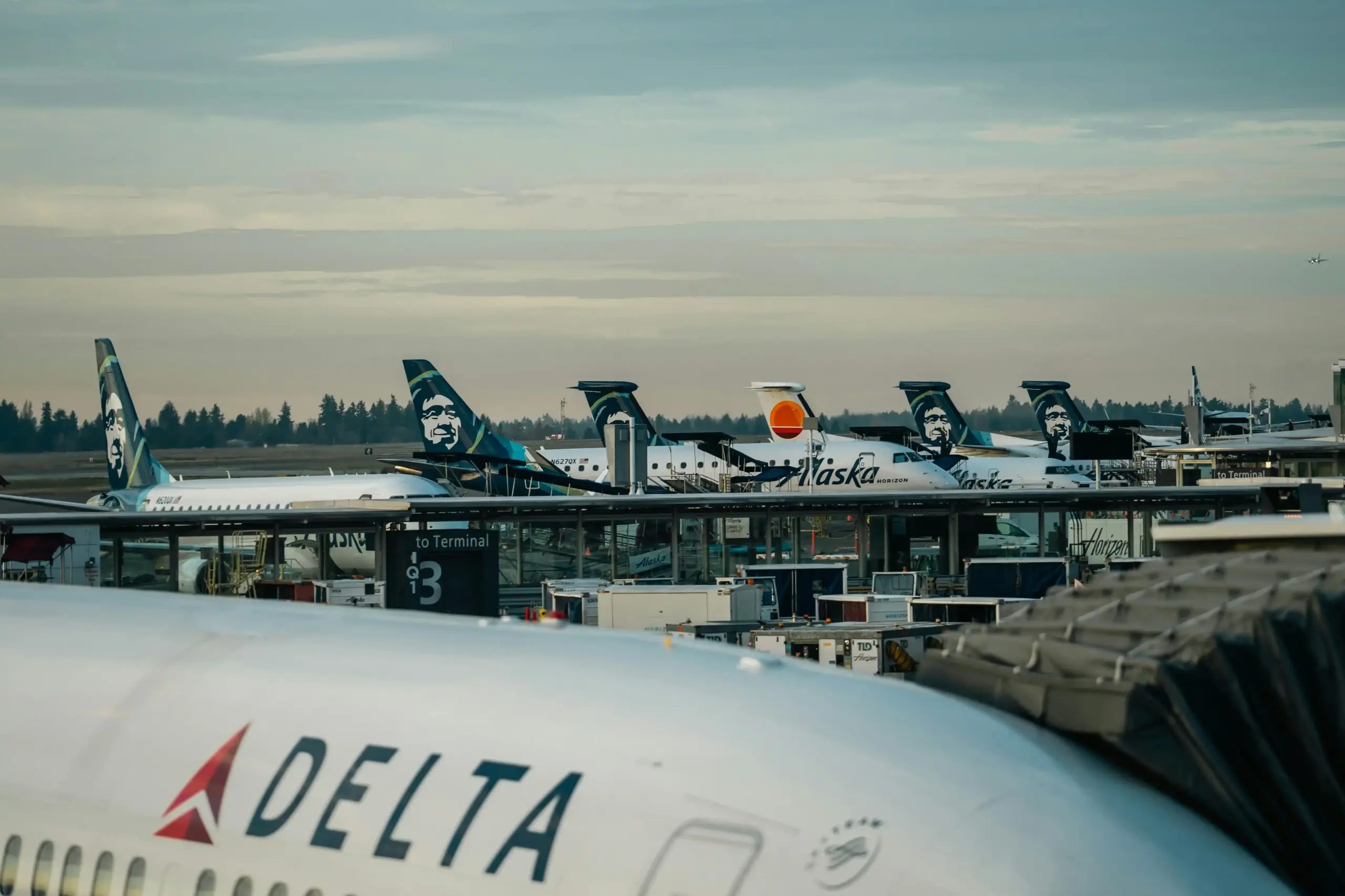 black luxury SUV parked at Seattle-Tacoma International Airport departures area before dawn, soft runway lights in background, chauffeur in dark suit opening passenger door, rea...