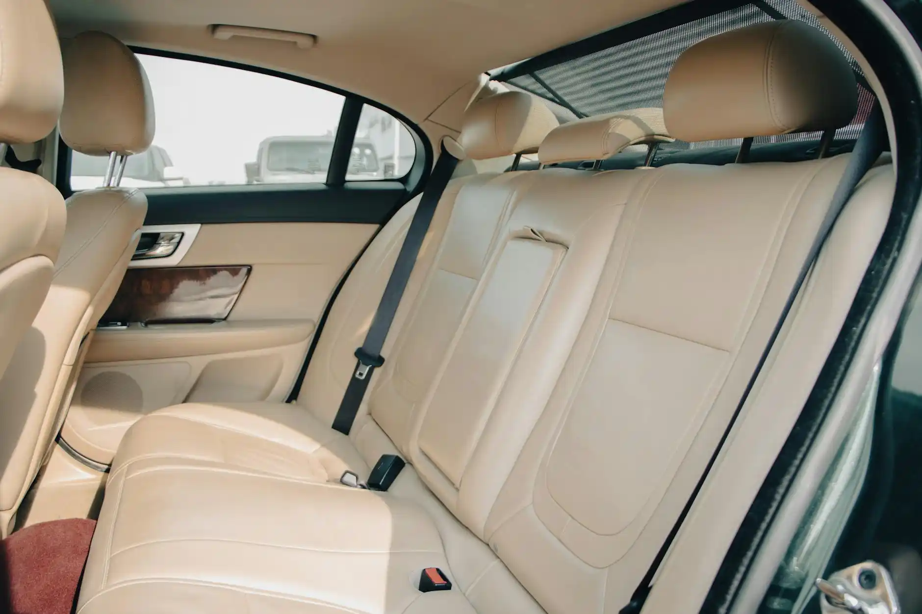 elegant black luxury sedan interior with leather seats, bottled water, soft ambient lighting, clean windows showing Seattle skyline and overcast afternoon