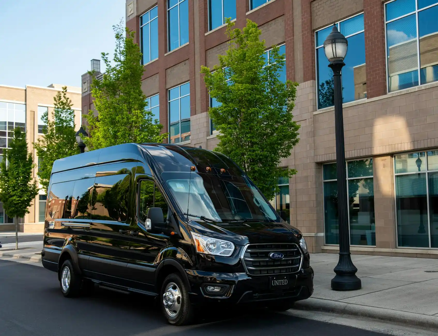 clean curbside pickup scene in Seattle's South Lake Union with a black shuttle van, glass office buildings, travelers checking phones, rain-slick streets reflecting city lights
