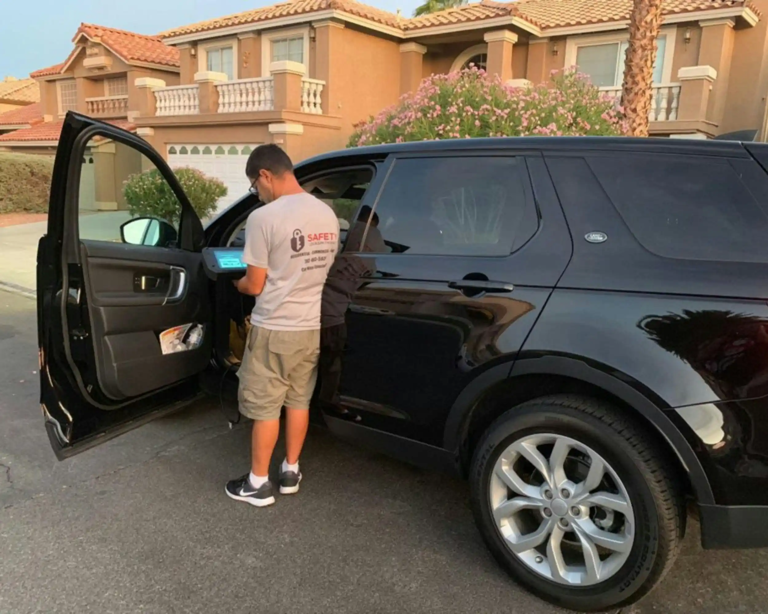 close-up of a driver opening the door of a luxury black town car for guests outside a boutique winery, polished vehicle details, wine barrels and flower boxes visible nearby