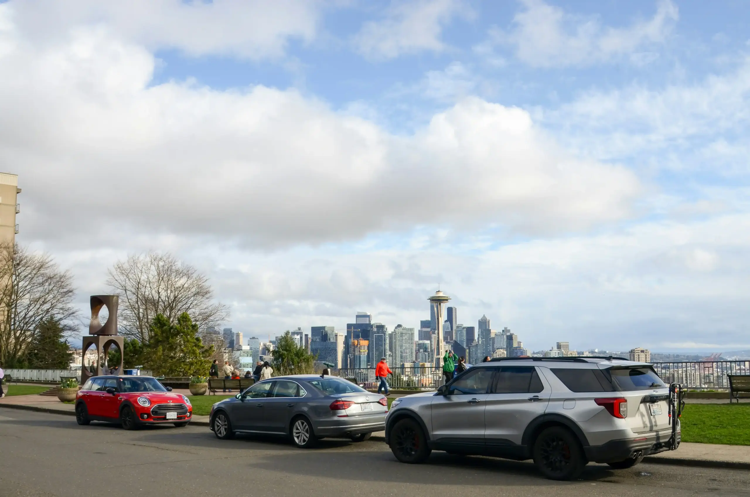 black luxury sedan parked on the tarmac side near Boeing Field private aviation terminal at sunrise, professional chauffeur opening rear door, Seattle skyline faintly visible in...