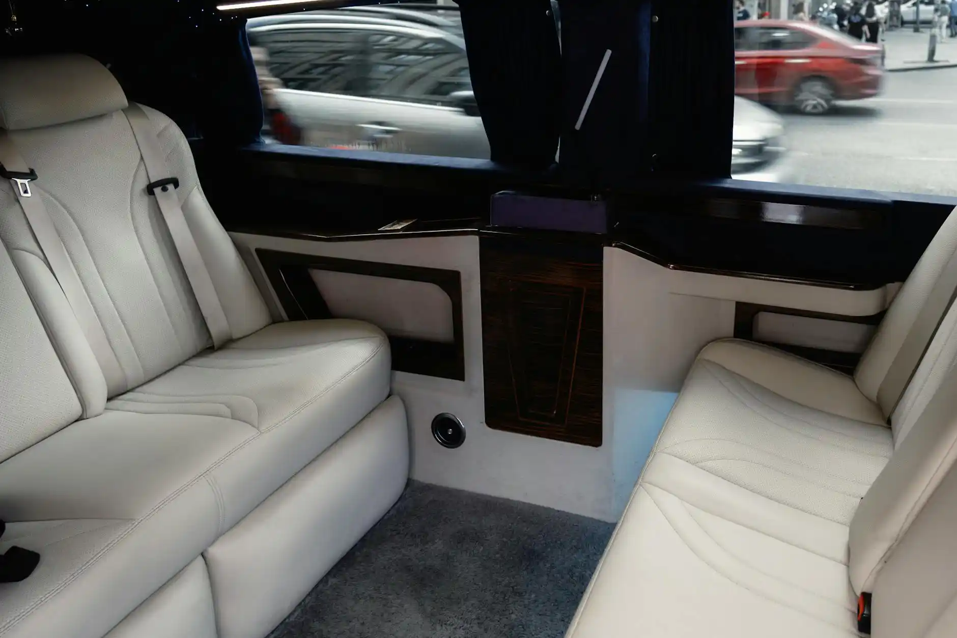 interior of a premium black limousine with soft leather seats, subtle ambient lighting, bottled water, and a laptop open on a passenger’s lap during a Seattle airport transfer