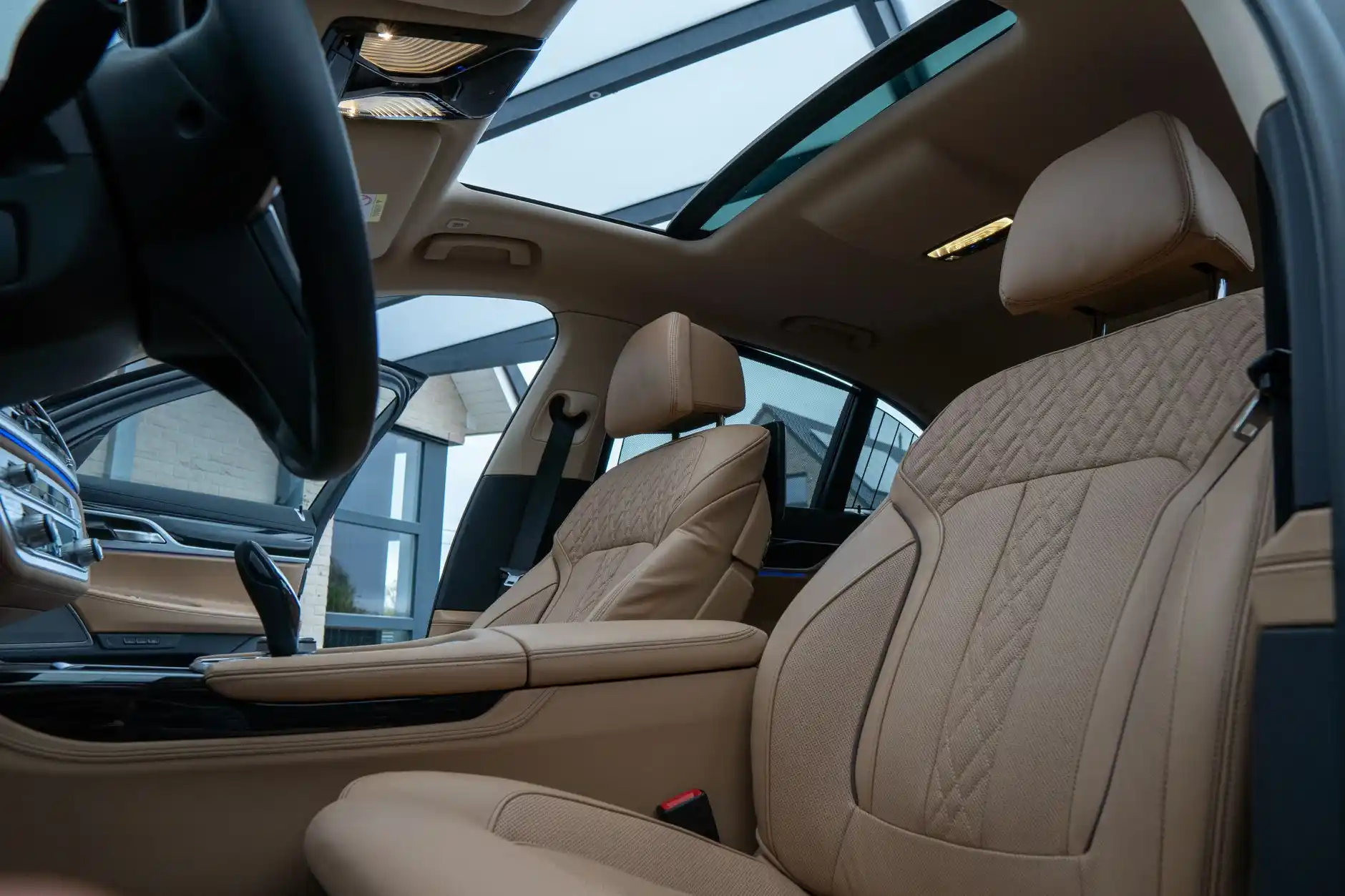 luxury SUV interior with captain seats, soft ambient lighting, bottled water, phone charging ports, and concert tickets on center console