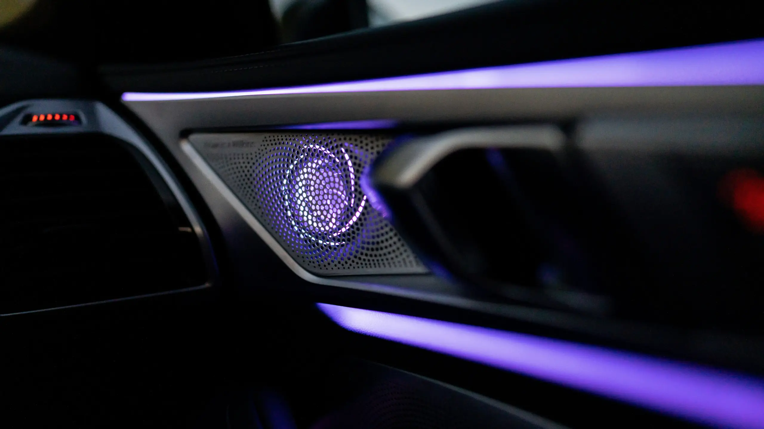 interior of a luxury black car with tan leather seats, bottled water, soft ambient lighting, and a view of Seattle freeway traffic through the windshield