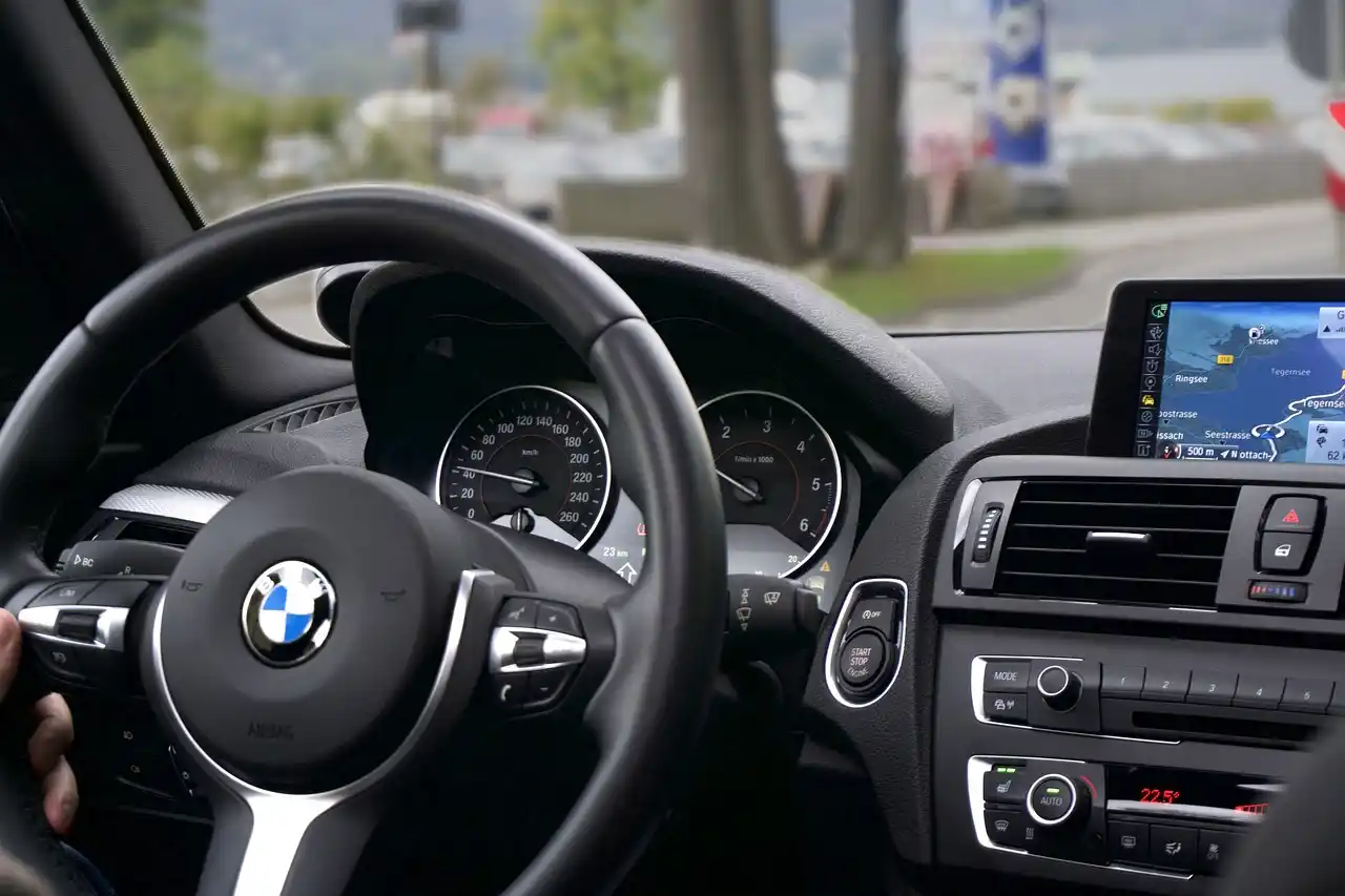 close-up interior of a premium black town car with stitched leather seats, bottled water, phone charging ports, soft ambient lighting, and neatly folded umbrellas