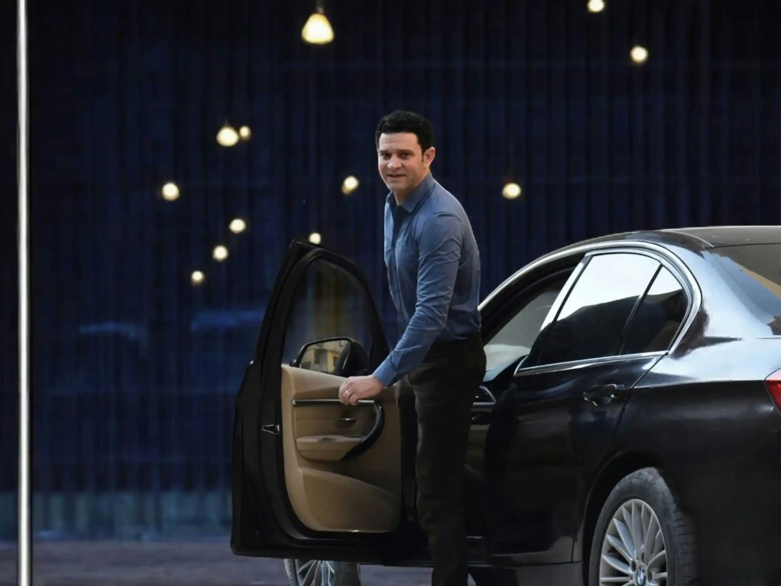 black luxury SUV arriving at a covered entrance of a Seattle fine dining restaurant at twilight, chauffeur opening the door for business travelers with briefcases