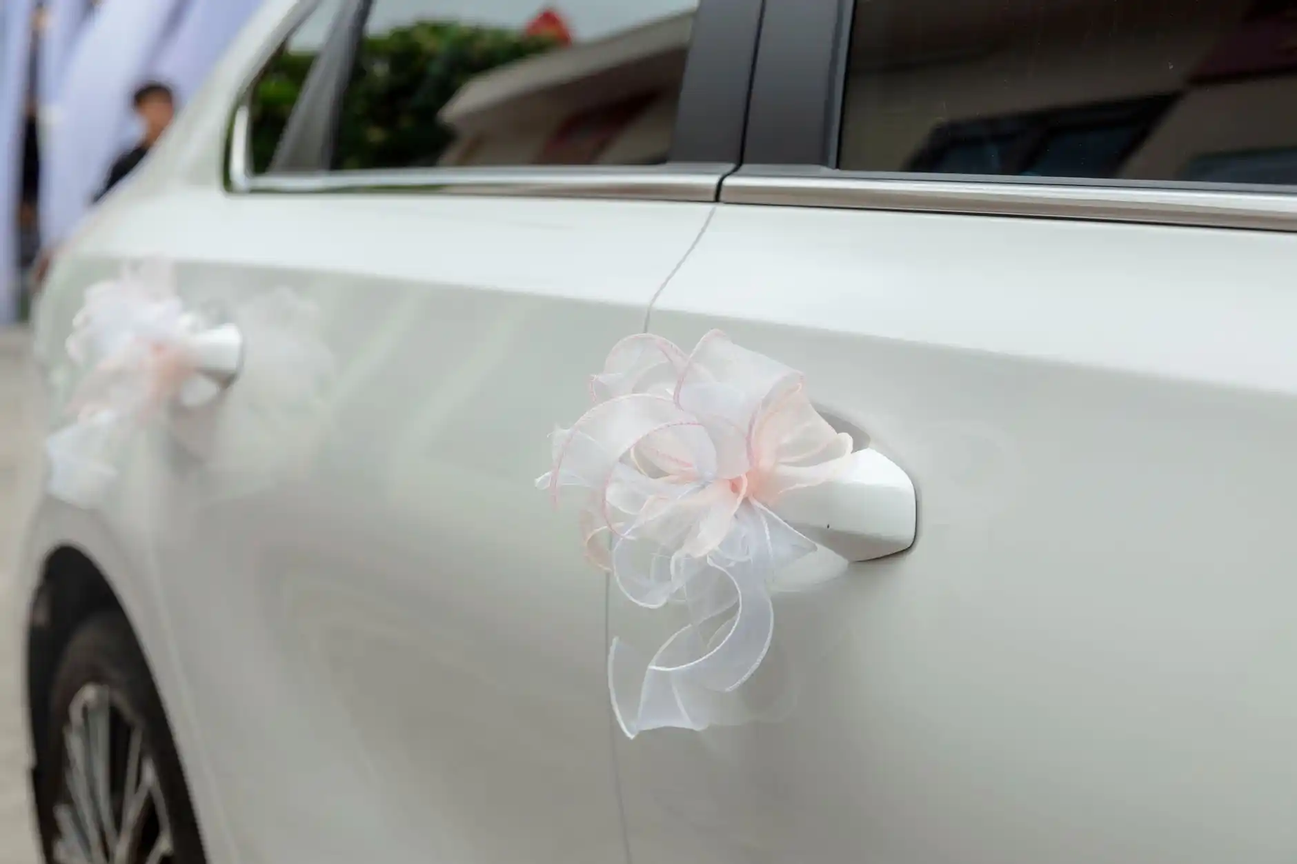 wedding planner clipboard with transportation timeline, Seattle venue map, calligraphy invitations, and car keys on a wooden table beside white roses