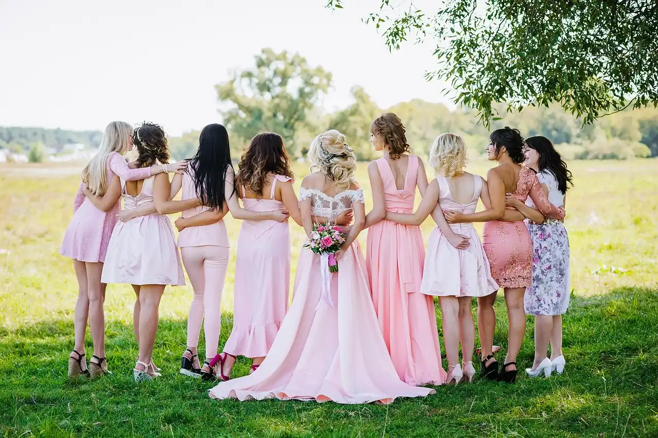 bridal party in formal attire entering a luxury black SUV outside a waterfront Seattle venue, bouquets, city skyline, and soft evening light