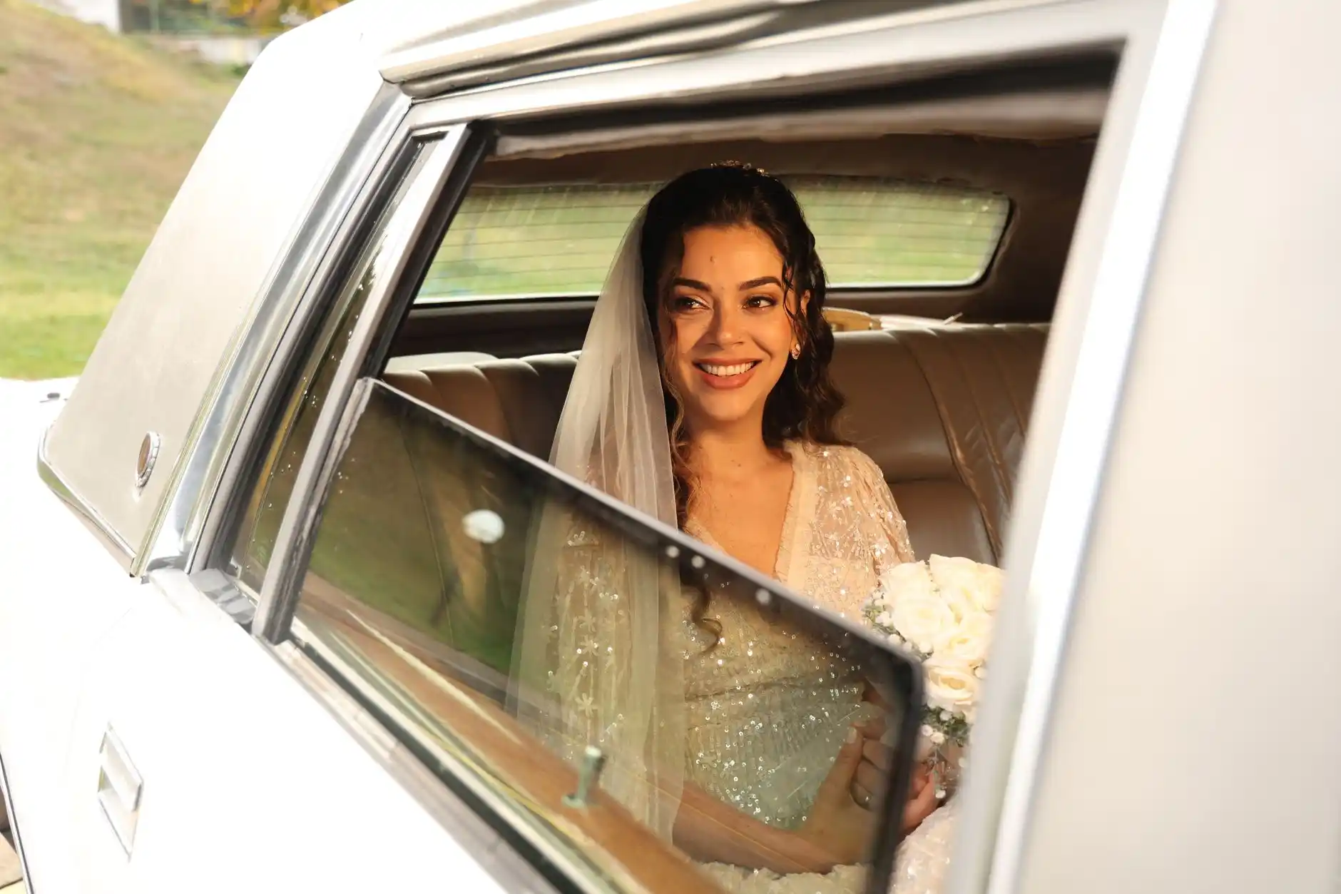 romantic rainy Seattle wedding arrival with chauffeur holding black umbrella for bride stepping from luxury limousine at a historic venue entrance