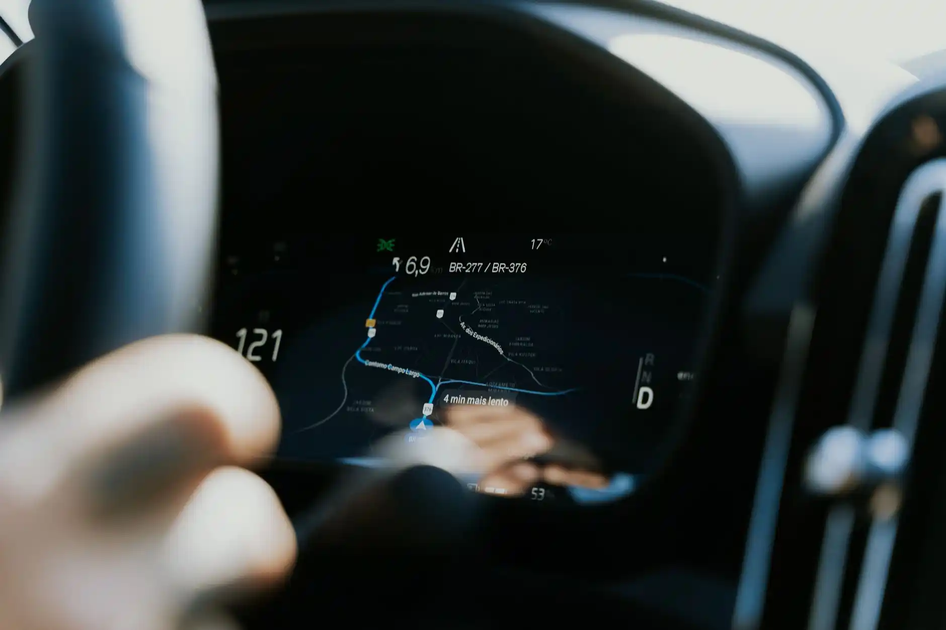 driver-side view from a luxury black sedan on wet I-90 approaching Seattle at sunrise, dashboard navigation showing alternate airport route, soft rain on windshield