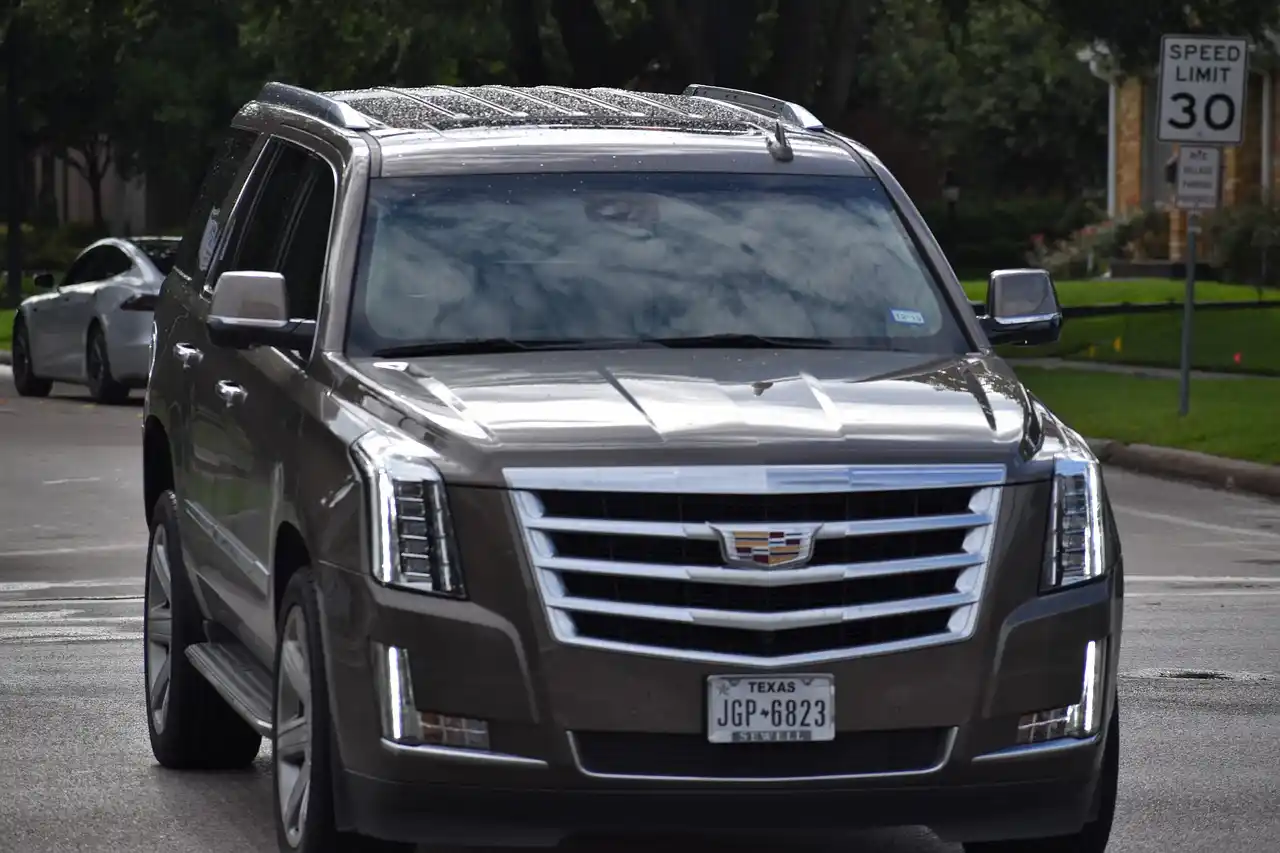 black luxury SUV at SeaTac airport arrivals curbside with large luggage and mountain scenery blended in the distance, realistic travel service scene