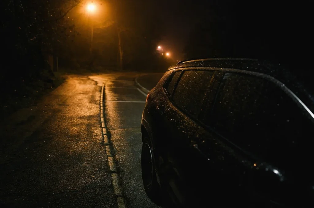 Black car at a well-lit pickup point at night for a safe return